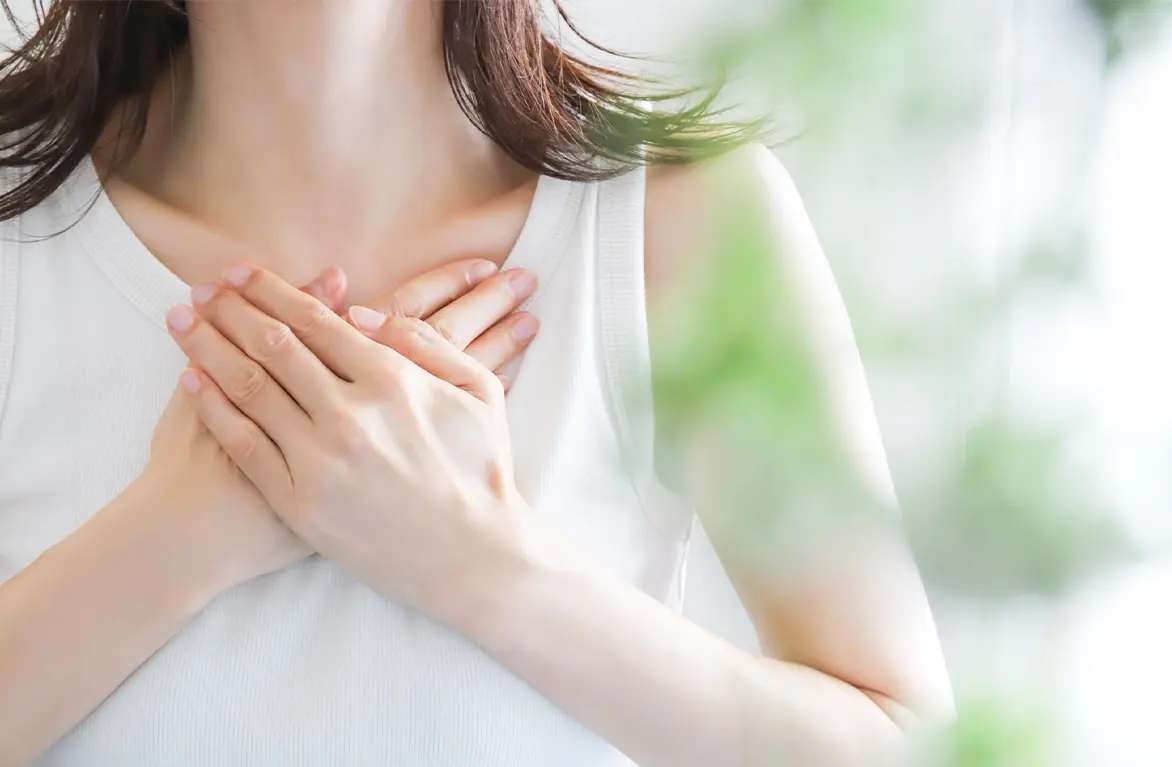 胸に手を当てる女性