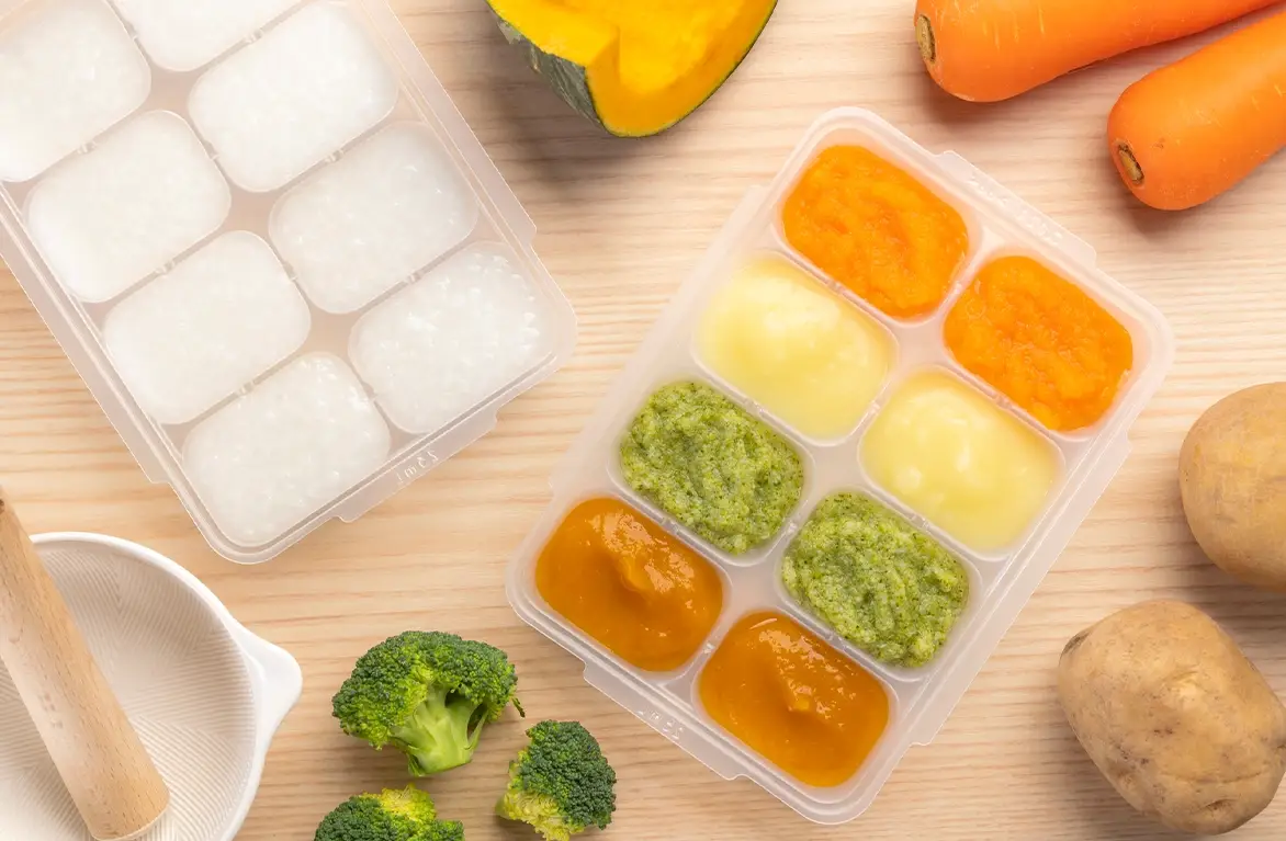 トレーに保存した離乳食と、にんじん・かぼちゃなどの野菜