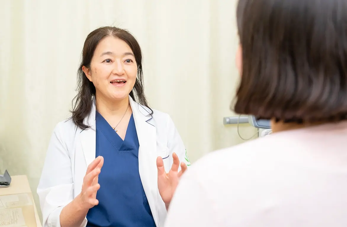 診察室で患者に説明する笑顔の女性医師