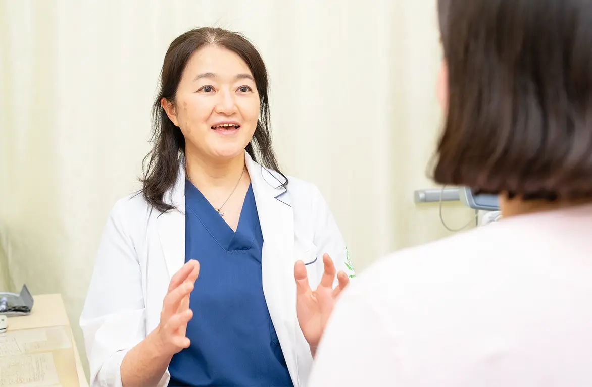笑顔で話す医師による妊婦健診の診察風景