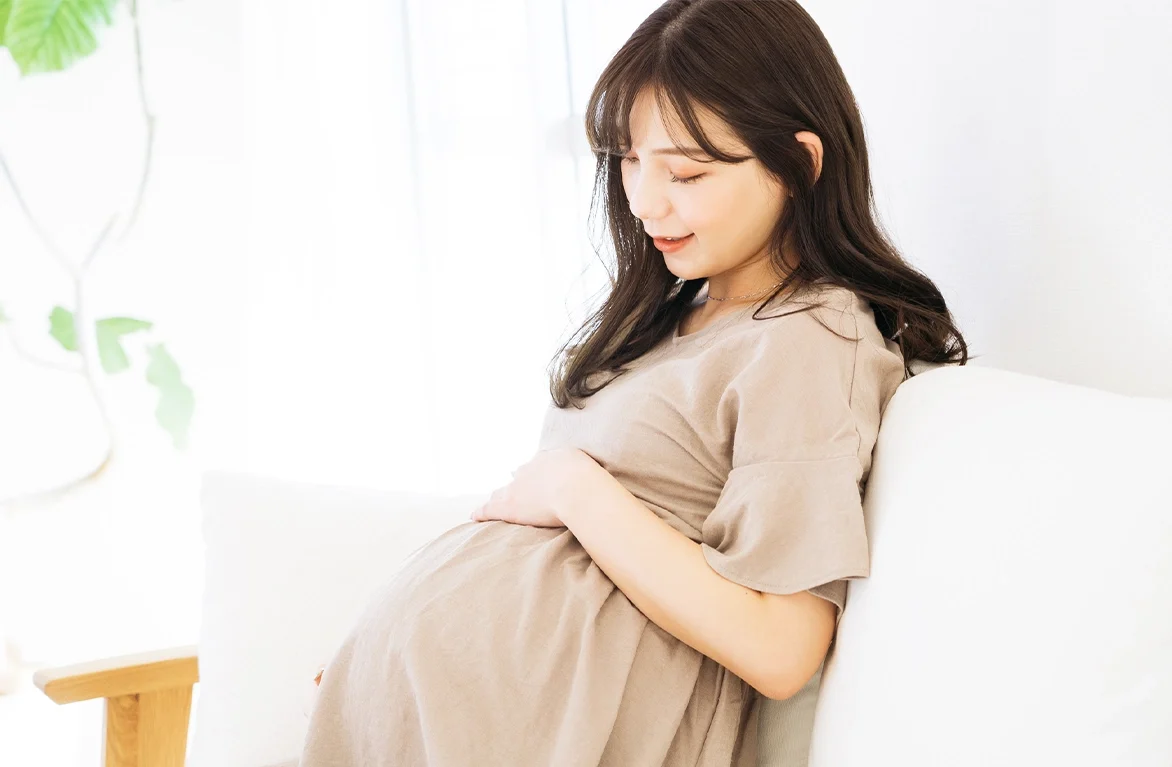 笑顔でお腹を撫でる妊婦さん