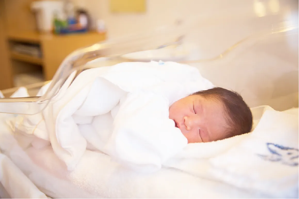 ベビーコットで安らかに眠る新生児